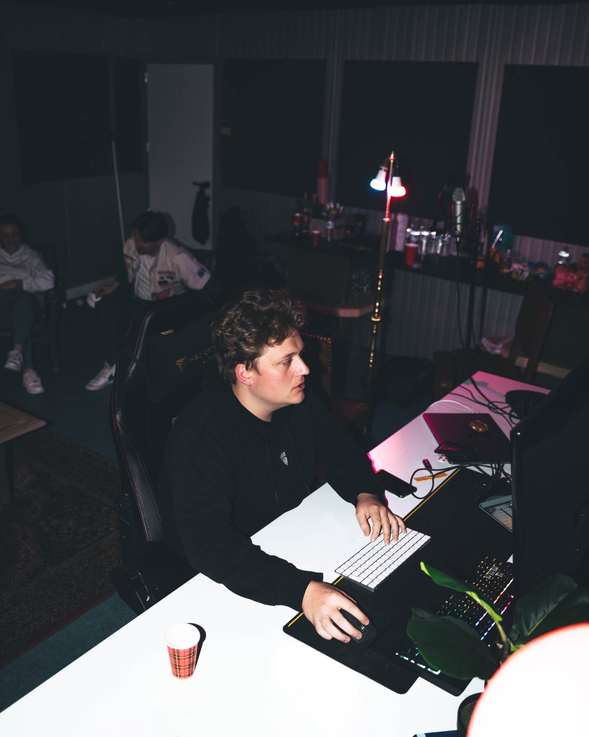 Producer Punbeatz working behind his desk in a dark studio at night
